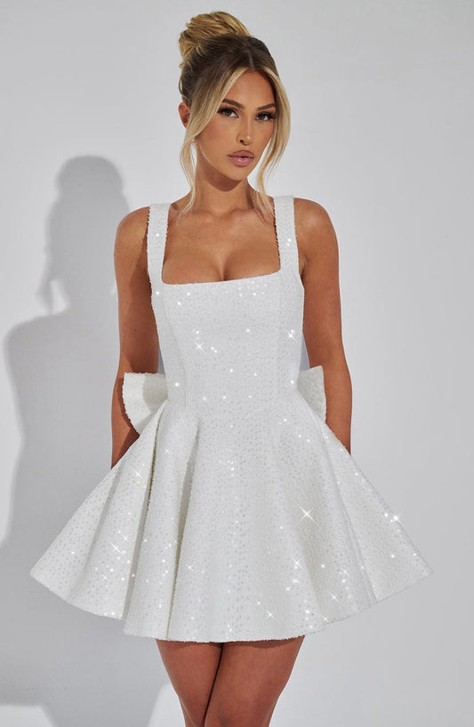 Front view of a white sequin mini dress with a square neckline and a large bow detail at the back, perfect for wedding suits for women.