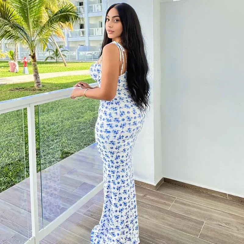 Back view of the Brooke Floral Maxi Dress, showcasing the blue floral pattern and flattering fit as the woman looks over her shoulder.