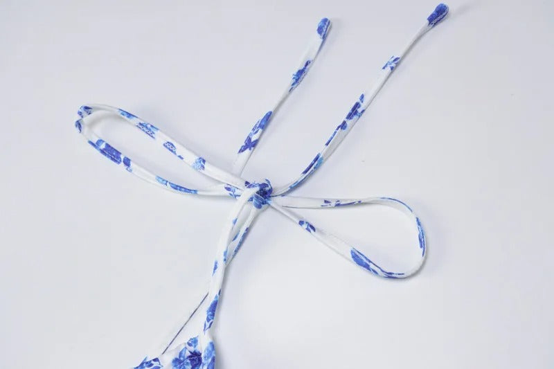 Close-up of the delicate white and blue floral print strap detail on the Brooke Floral Maxi Dress, tied in a bow.