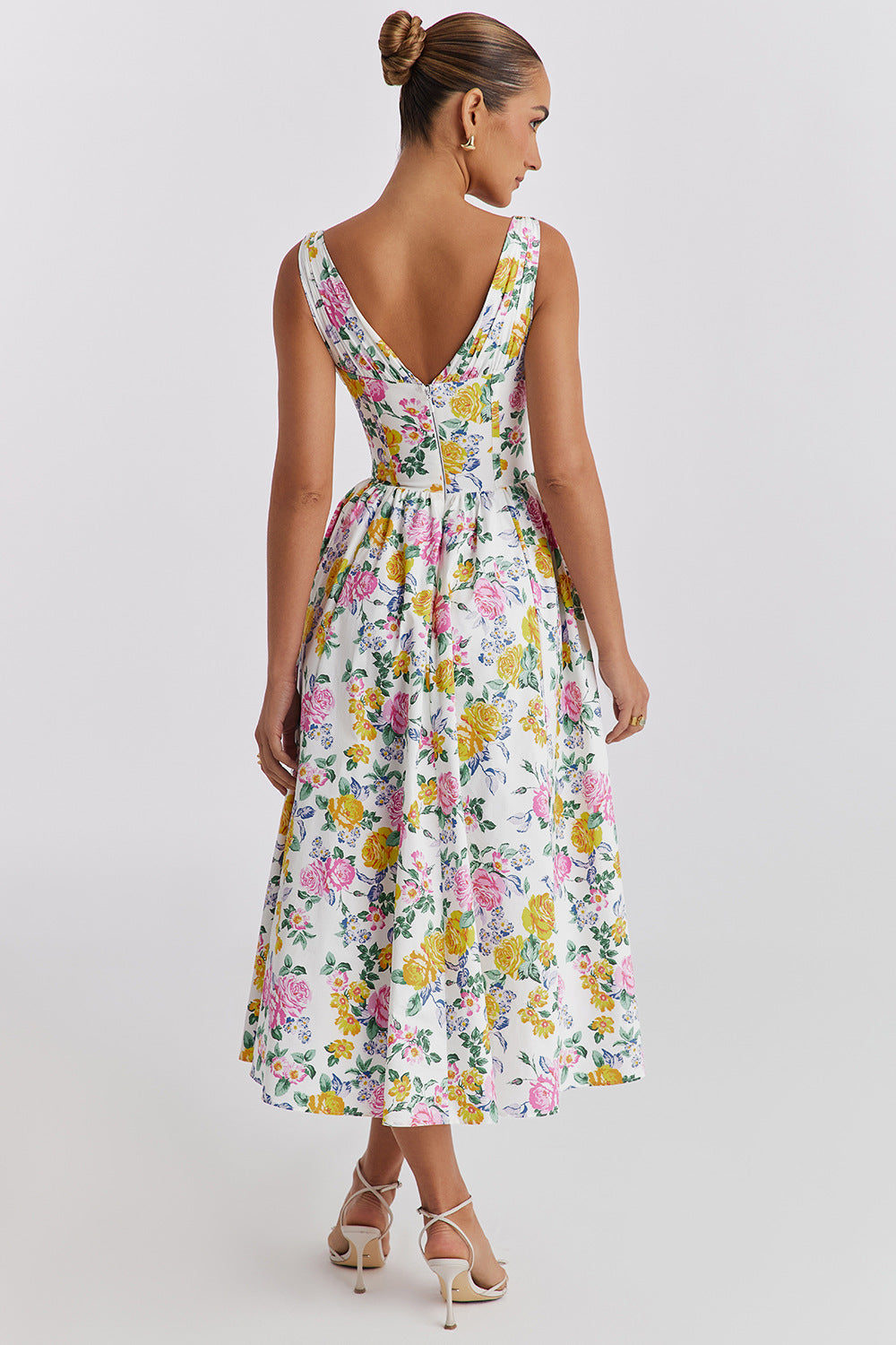 Back view of the white Dahlia Floral Midi Dress, showing the elegant V-back and full skirt with pink and yellow rose print.