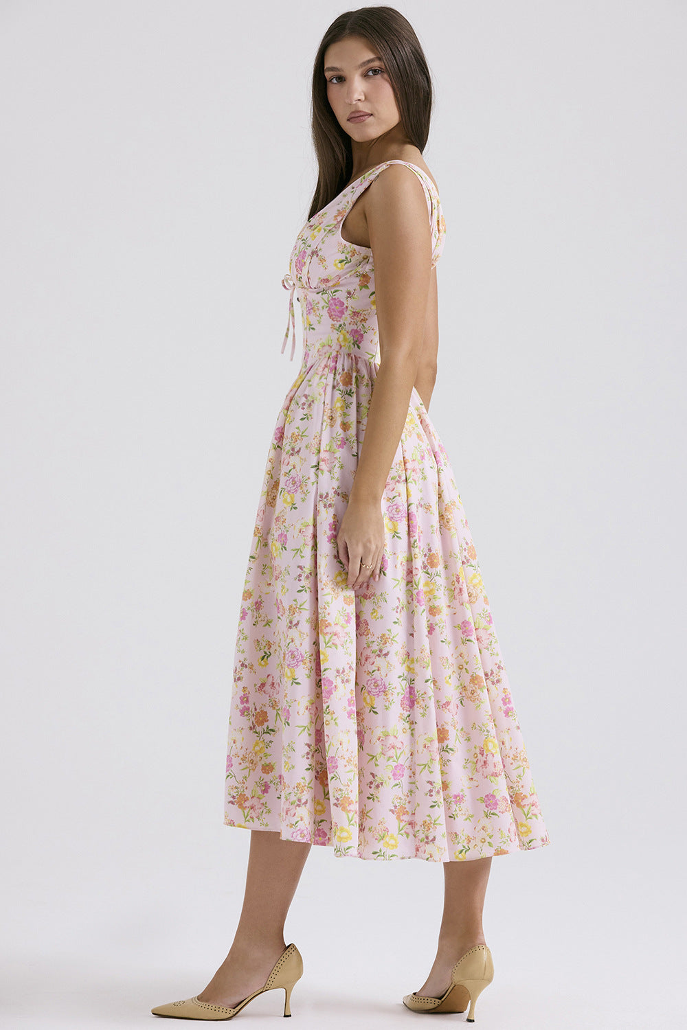 Side profile of the pink Dahlia Floral Midi Dress, showcasing the flowing midi skirt and fitted bodice with delicate floral pattern.