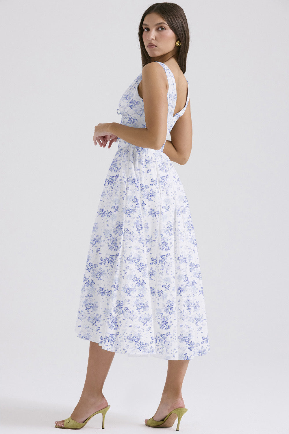 Side profile of the white and blue floral midi dress, highlighting the elegant silhouette and intricate blue floral design.