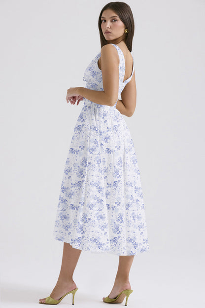 Side profile of the white and blue floral midi dress, highlighting the elegant silhouette and intricate blue floral design.