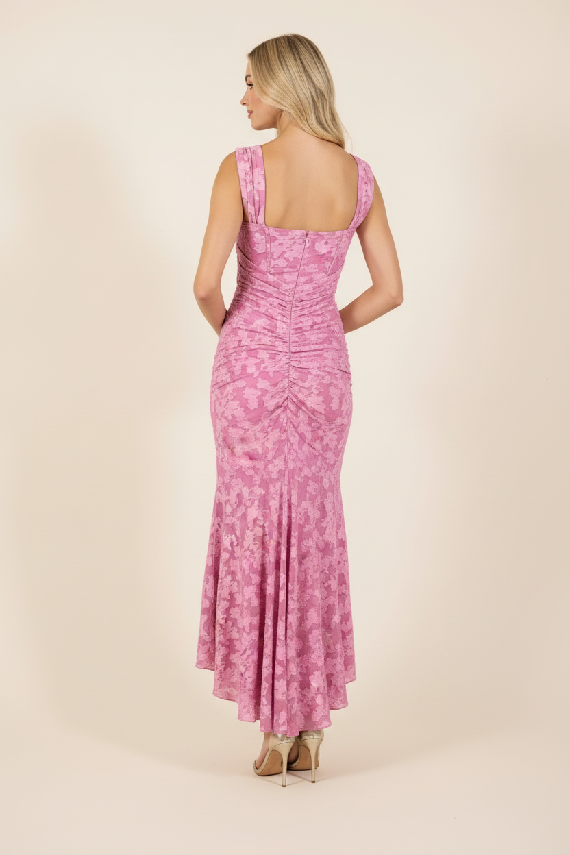 Back view of women's pink floral square-neck midi dress with ruched detail and high-low hem