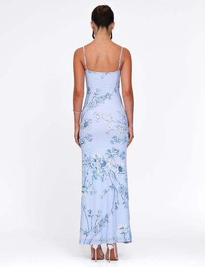 Back view of a light blue floral maxi dress, showing the delicate spaghetti straps and the continuous floral pattern down the back.