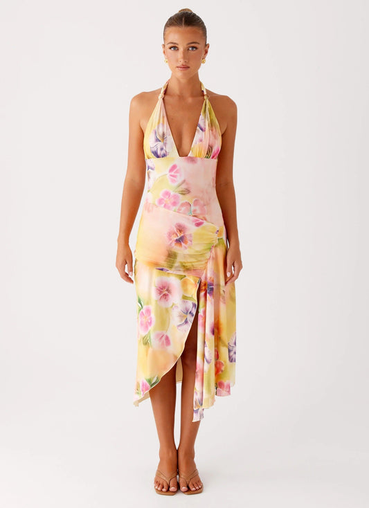Front view of a woman wearing the yellow, pink, and purple floral midi dress with a V-neck halter for women.