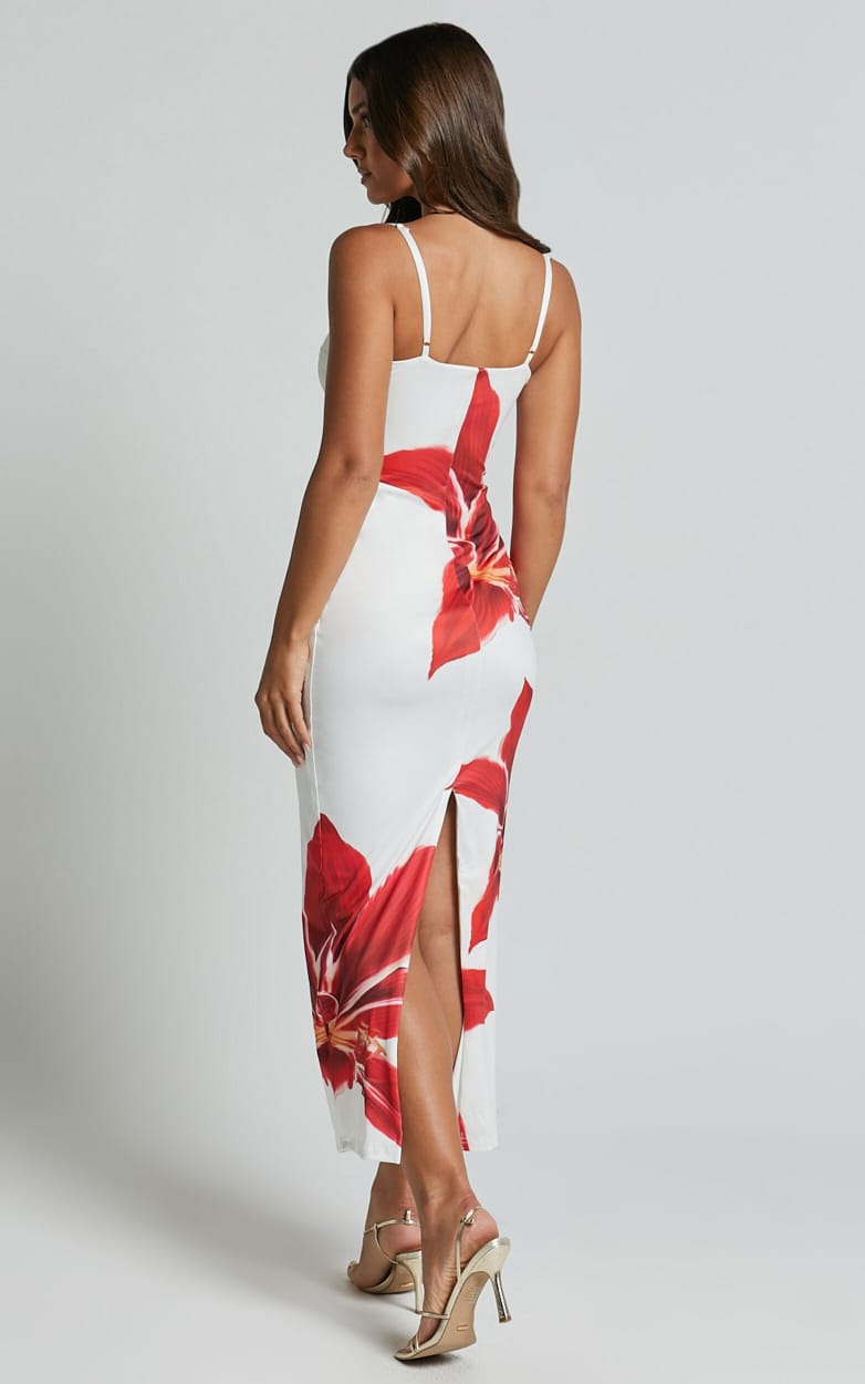 Back view of the white Harper floral midi dress with red lily design and a small back slit.