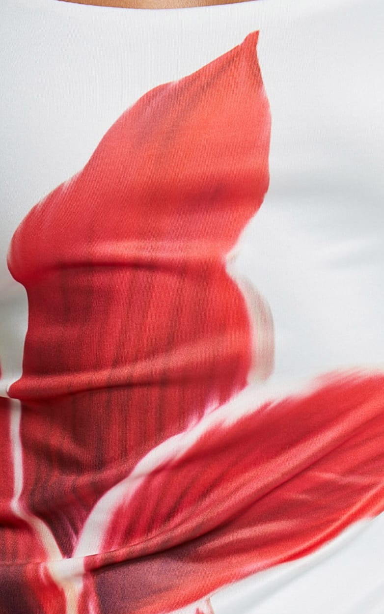 Close-up detail of the red lily floral print on the white fabric of the Harper midi dress.