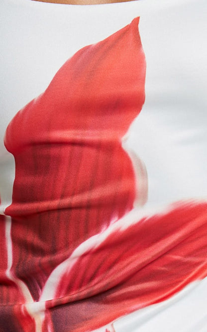 Close-up detail of the red lily floral print on the white fabric of the Harper midi dress.