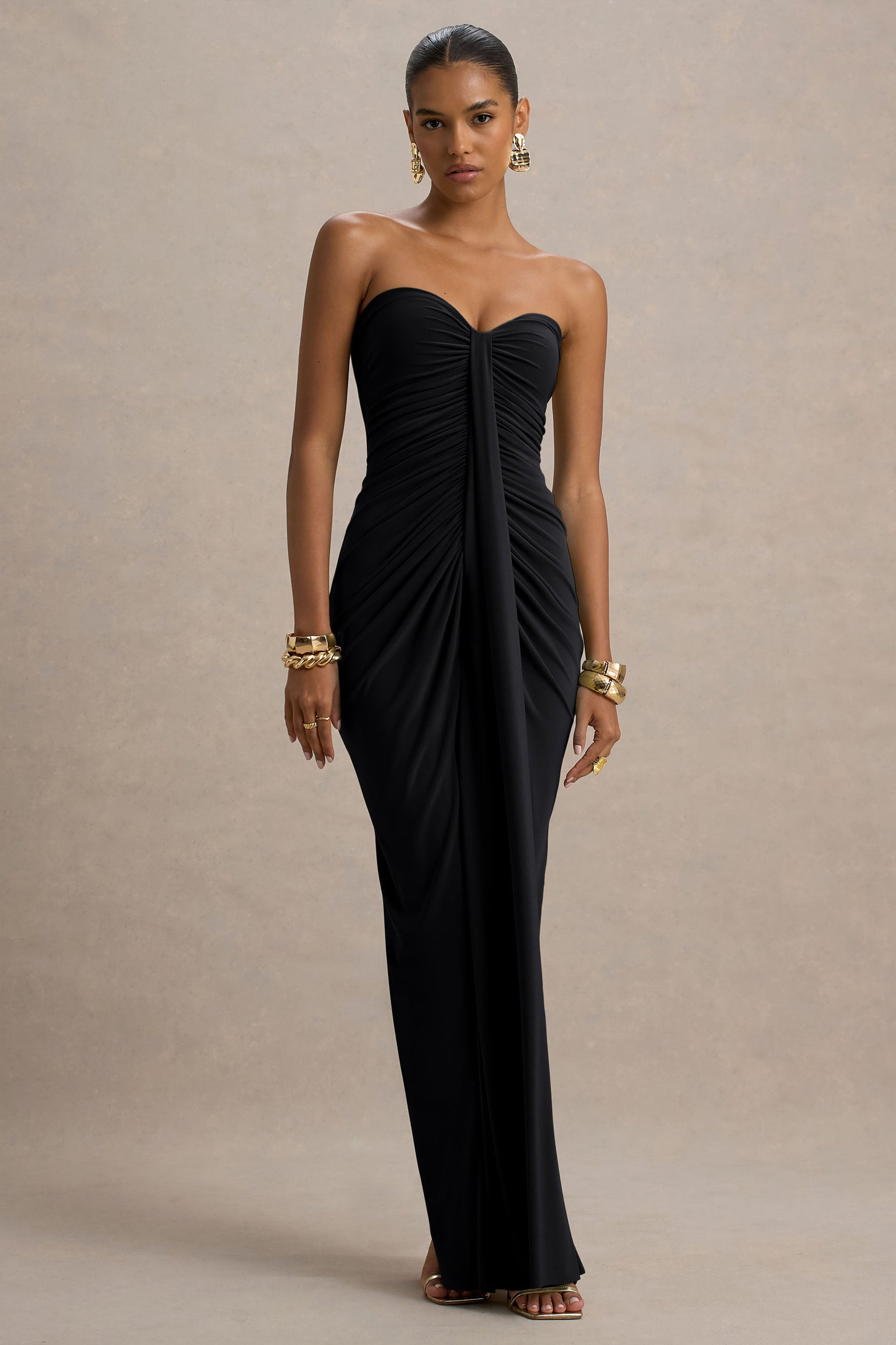 Full length view of a strapless black ruched maxi dress, featuring a sweetheart neckline and side draping.