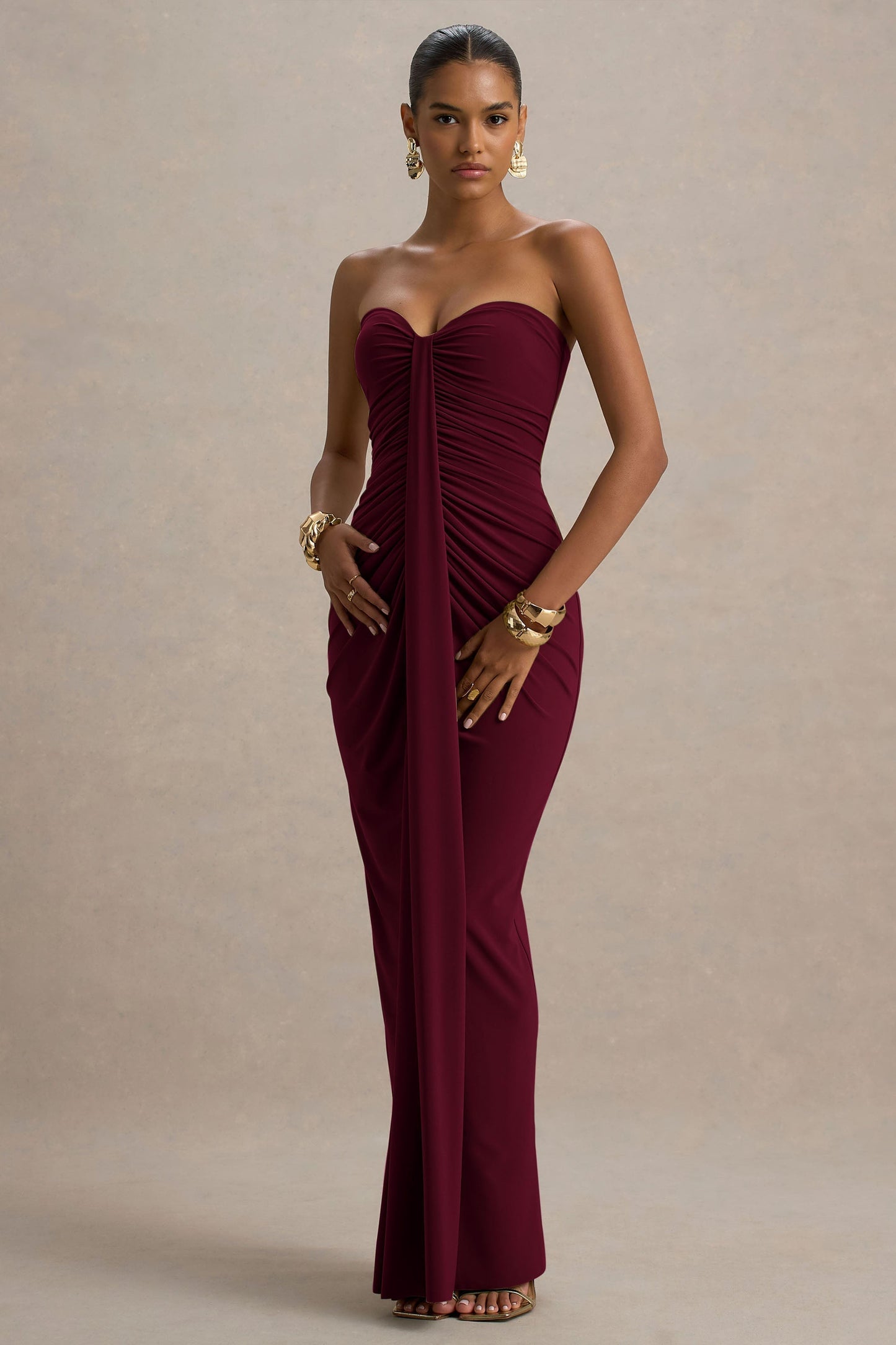 Front view of a burgundy strapless ruched maxi dress, highlighting the fitted silhouette and elegant draping.