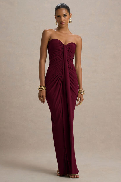 Full-length view of a strapless burgundy ruched maxi dress with a sweetheart neckline and center draping detail.
