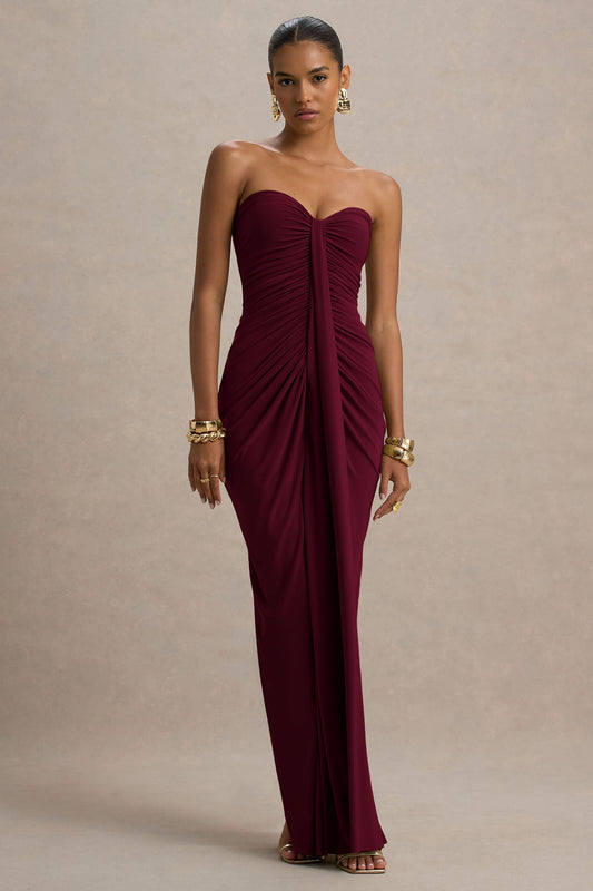 Full-length view of a strapless burgundy ruched maxi dress with a sweetheart neckline and center draping detail.