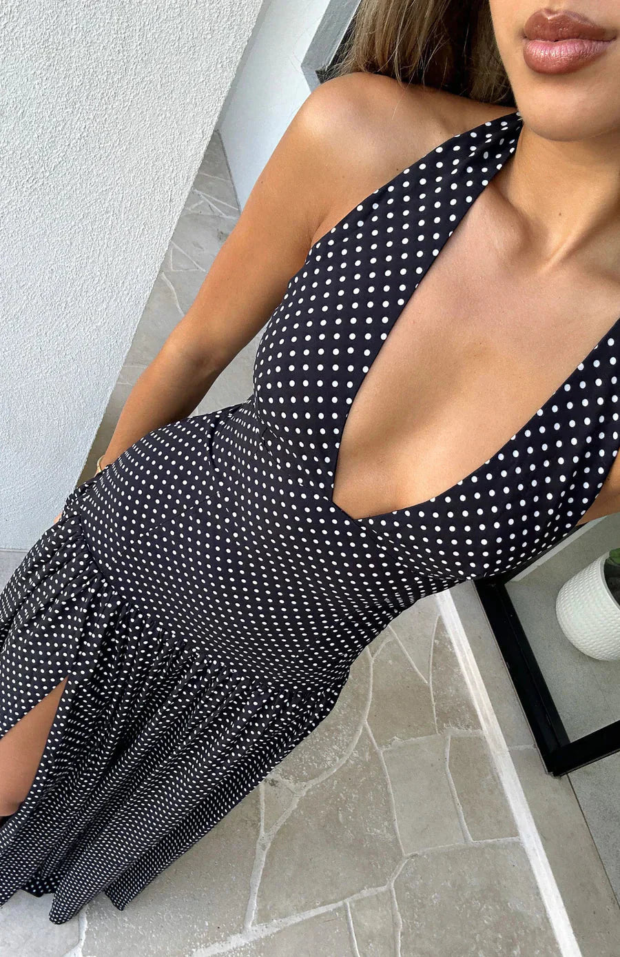Close-up of the black polka dot maxi dress, detailing the V-neckline and fabric texture.
