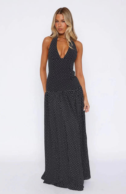 Black polka dot maxi dress with a deep V-neck halter top and full skirt, perfect for a summer dress.