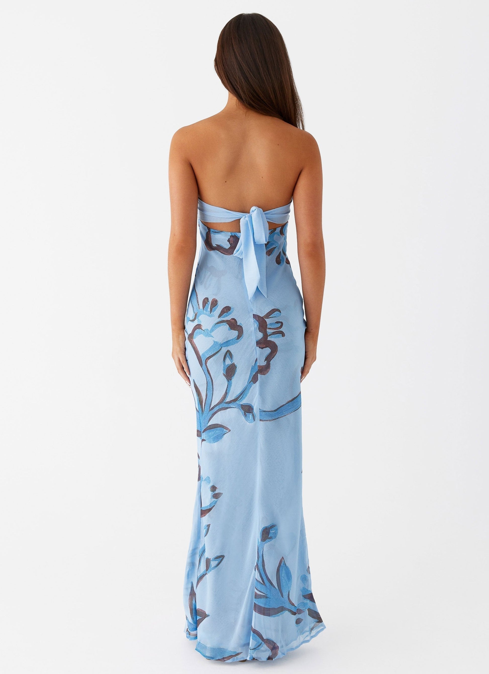 Back view of light blue Lyra Floral Maxi Dress with dark blue floral print and tie-back closure.