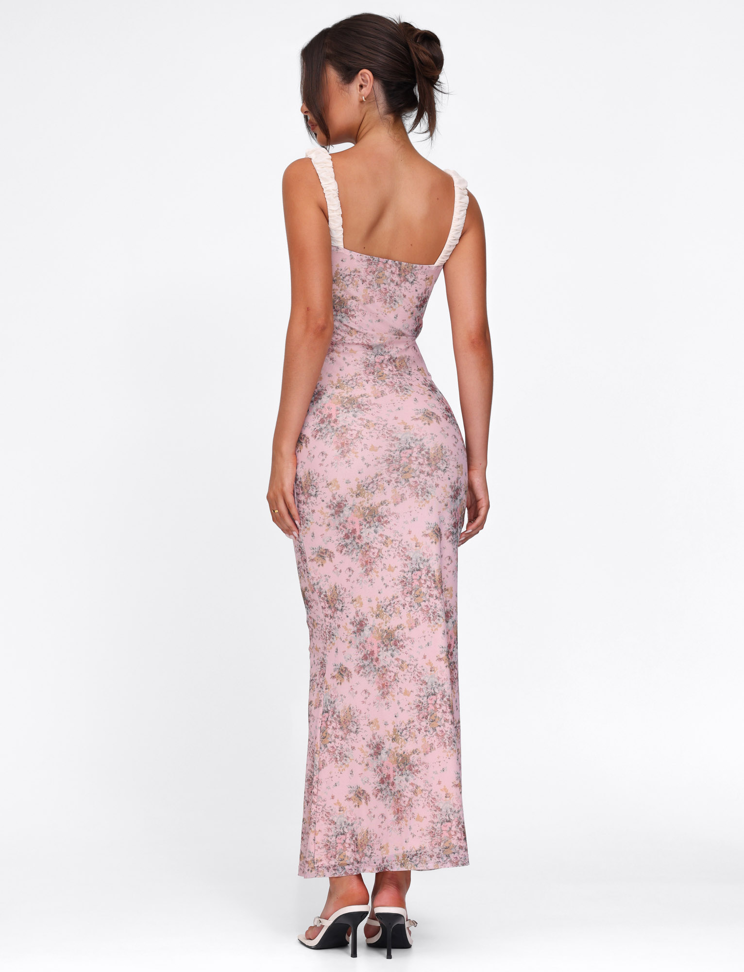 Back view of the pink floral maxi dress, showing the fitted design and white ruffled straps, ideal for a chic look.