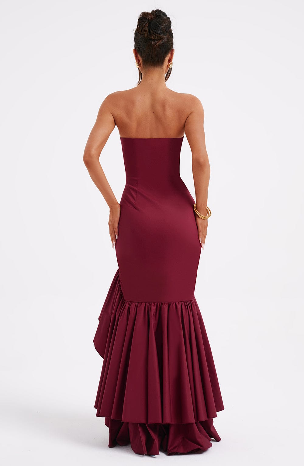 Back view of a woman in a strapless burgundy Marlowe Ruffle Maxi Dress, showcasing the tiered ruffled mermaid skirt.