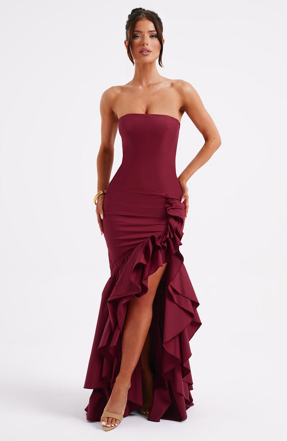 Marlowe Ruffle Maxi Dress in a rich burgundy color, showcasing the strapless design, fitted bodice, and voluminous high-low ruffle skirt with a leg slit.