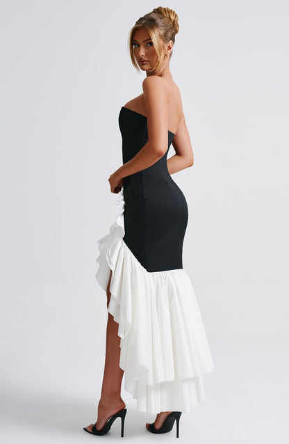 Side profile of the Marlowe Ruffle Maxi Dress in black with a white high-low ruffle skirt, emphasizing the dramatic volume of the ruffles and the silhouette.