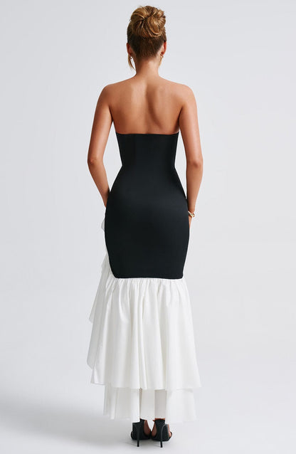 Back view of the Marlowe Ruffle Maxi Dress in black with a white high-low ruffle skirt, showing the strapless back and layered skirt detail.