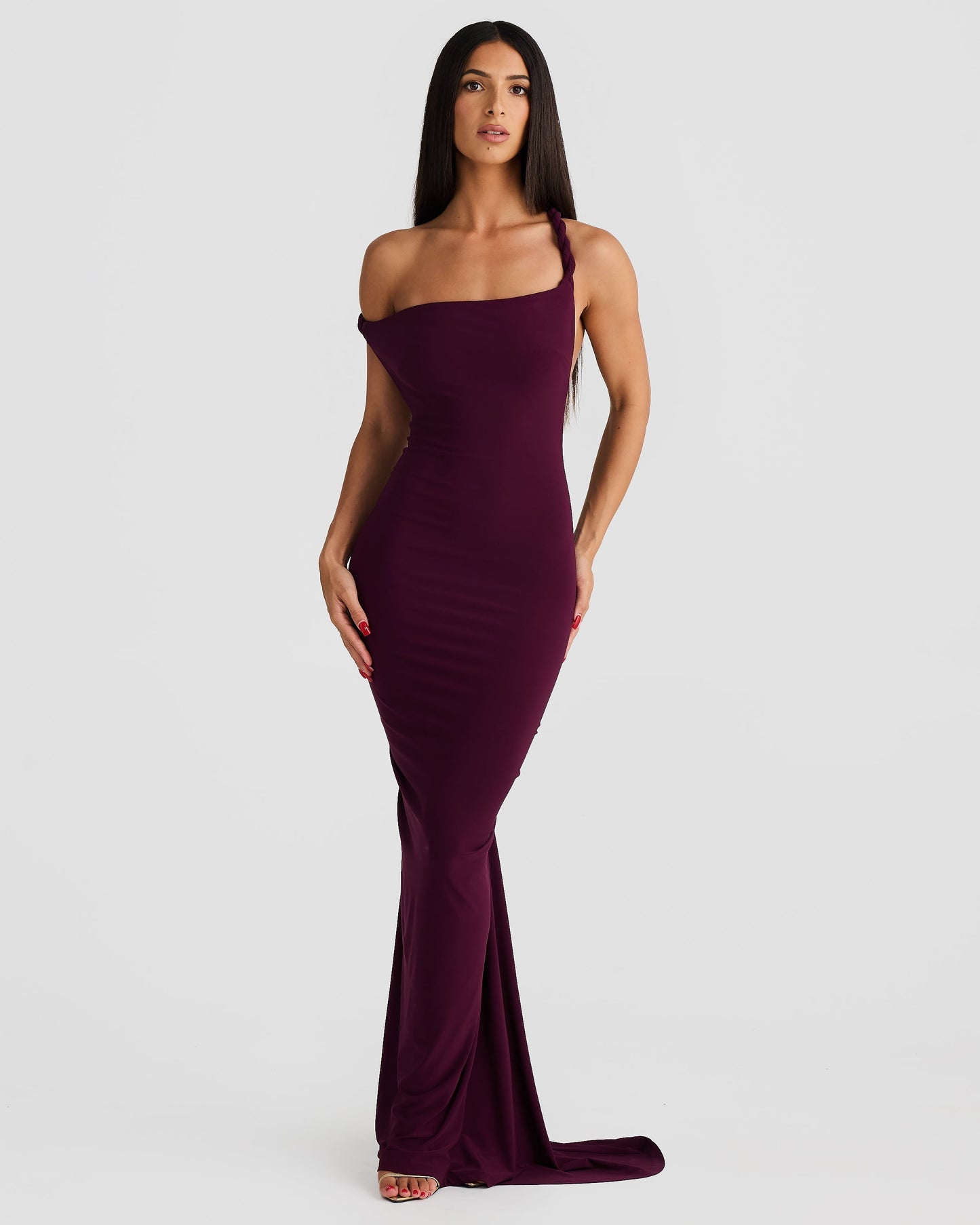 Front view of a woman in a plum purple Paulina backless maxi dress with a one-shoulder neckline and long skirt.