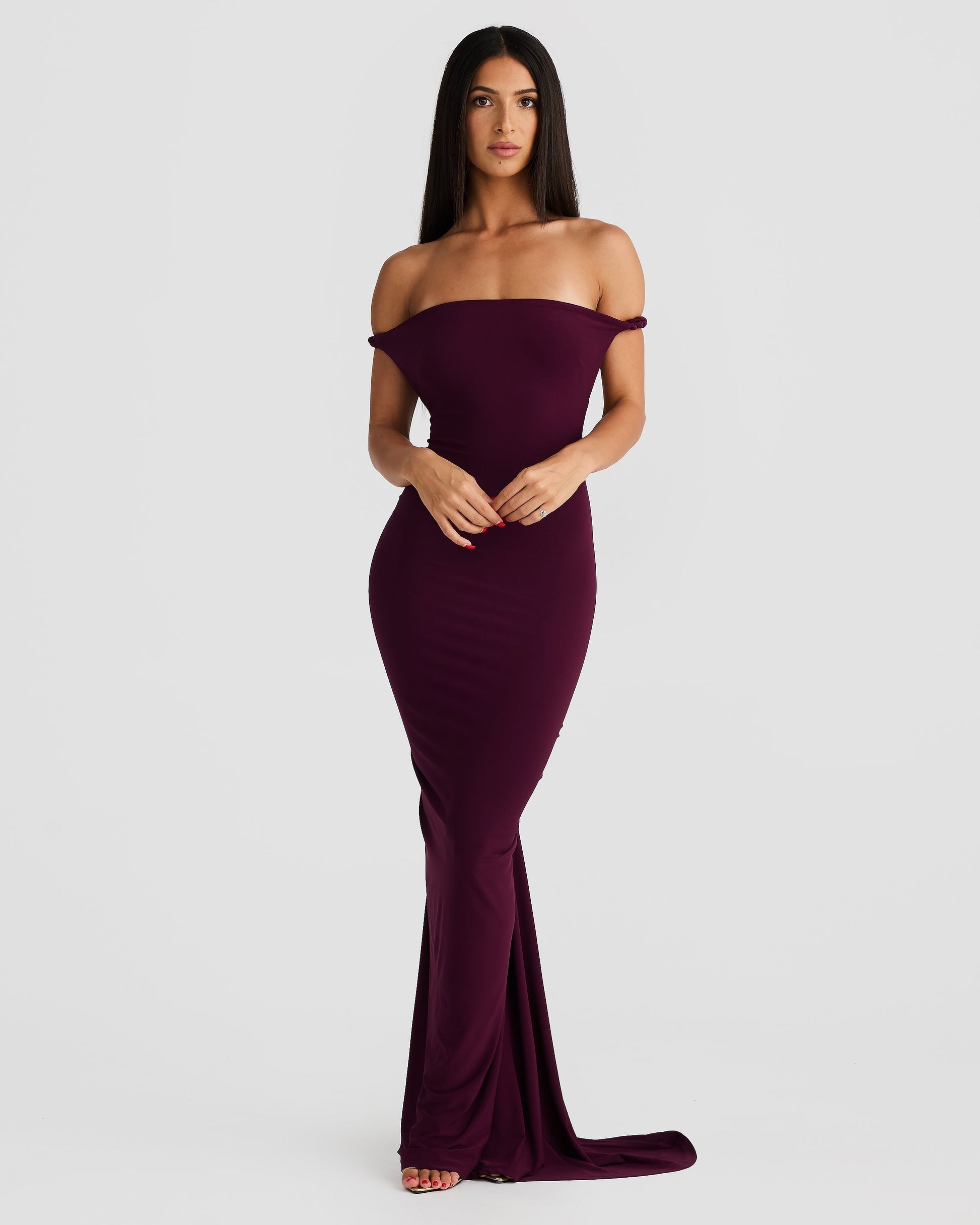Front view of a woman wearing a plum purple Paulina maxi dress with an off-the-shoulder neckline and fitted silhouette.