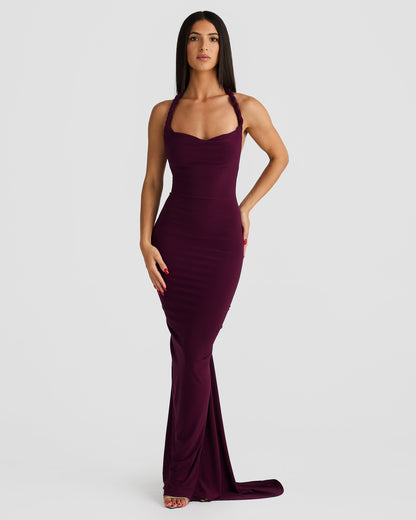 Front view of a woman in a plum purple Paulina backless maxi dress with a halter neckline and long, flowing skirt.
