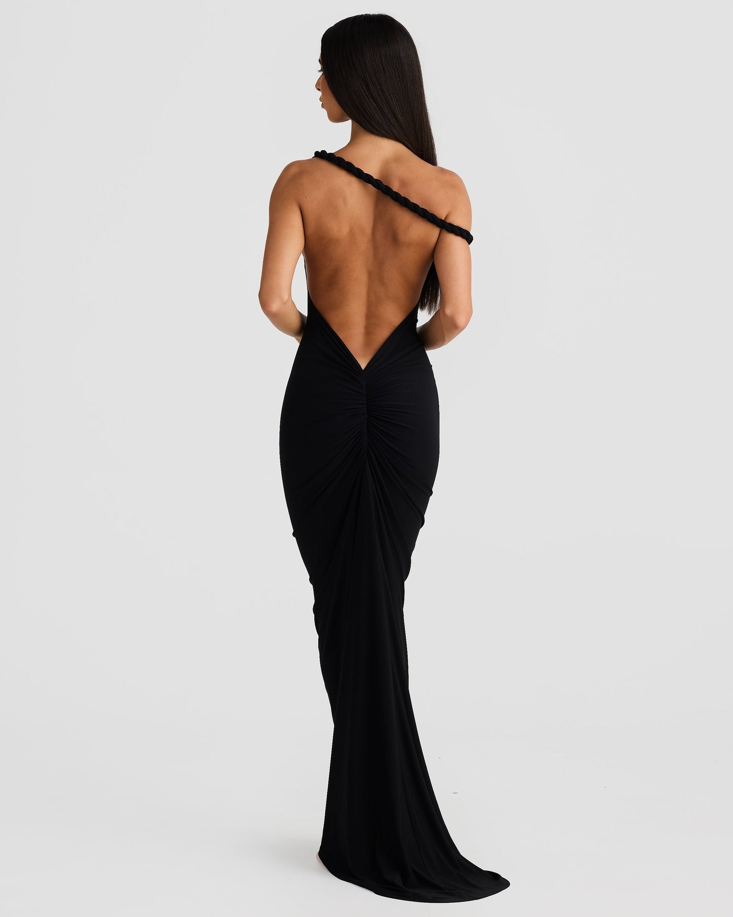 Rear view of the black Paulina backless maxi dress, highlighting the single braided strap and deep V-back.
