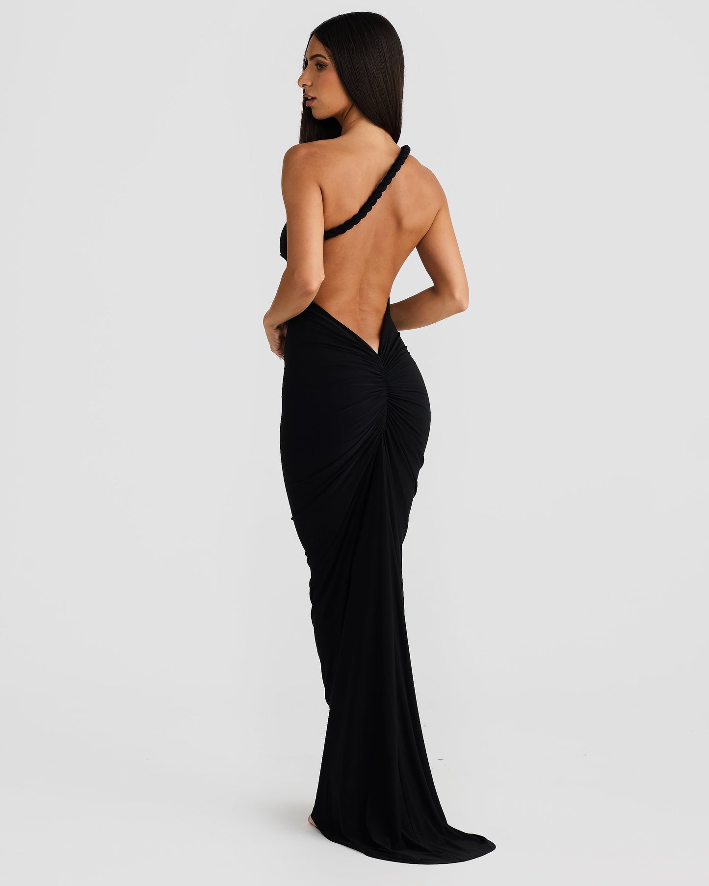 Back view of the black Paulina backless maxi dress, with a unique braided strap and ruched detail at the lower back.