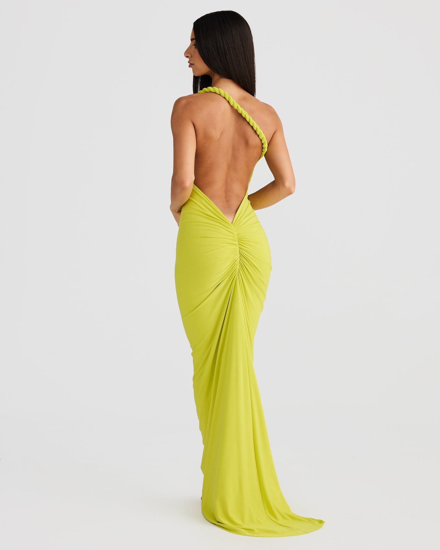 Rear view of a lime green Paulina backless maxi dress with a single braided strap and flowing train.