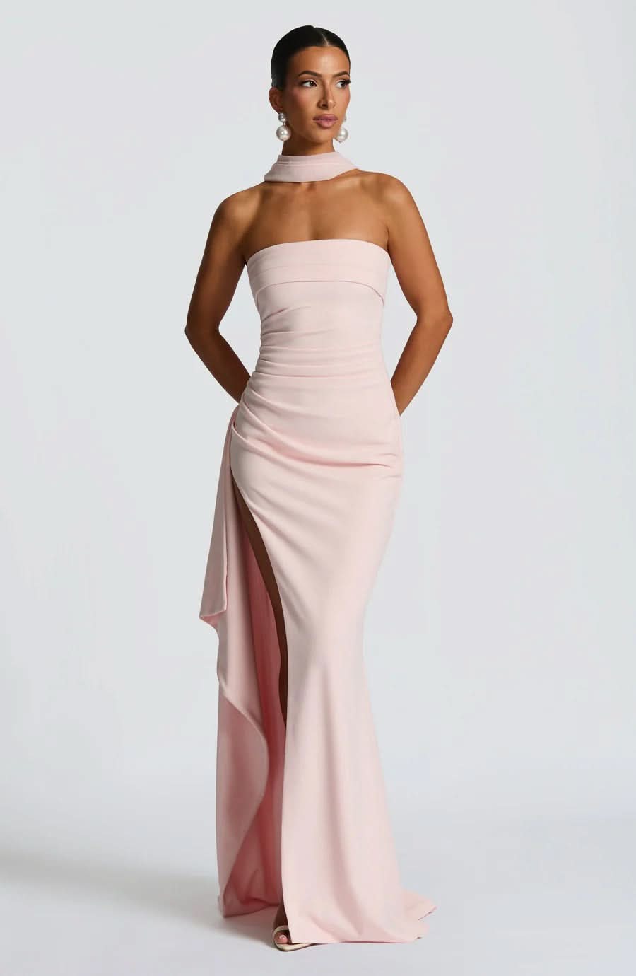 Elegant light pink strapless ruched maxi dress with a dramatic high slit, ideal for formal events or as a wedding dress.