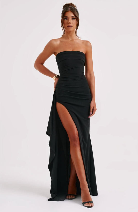 Black strapless maxi dress with side ruching and high slit, flowing layered skirt detail, elegant evening dress.