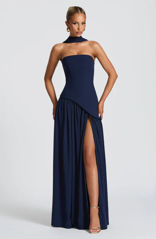 Full view of a navy blue Rhea Asymmetrical Maxi Dress, with a strapless design, high leg slit, and choker neckline.