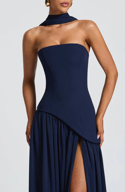 Close-up of the navy blue Rhea Asymmetrical Maxi Dress bodice, highlighting the strapless design and draped asymmetrical waist.