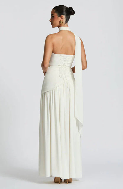Back of the ivory Rhea Asymmetrical Maxi Dress, displaying the lace-up back and the long, flowing scarf accent.