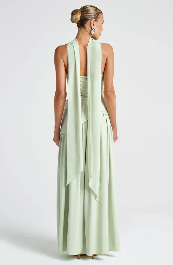 Back view of the light green Rhea maxi dress, showing the criss-cross lace-up detail on the bodice and long flowing ties.