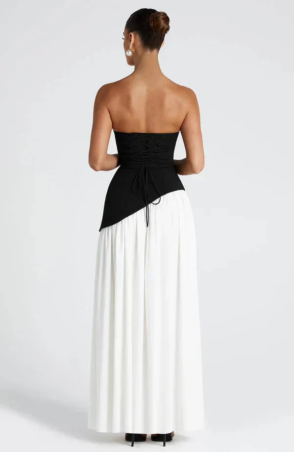 Back view of the black and white Rhea maxi dress, showing the contrast between the black lace-up bodice and white skirt.