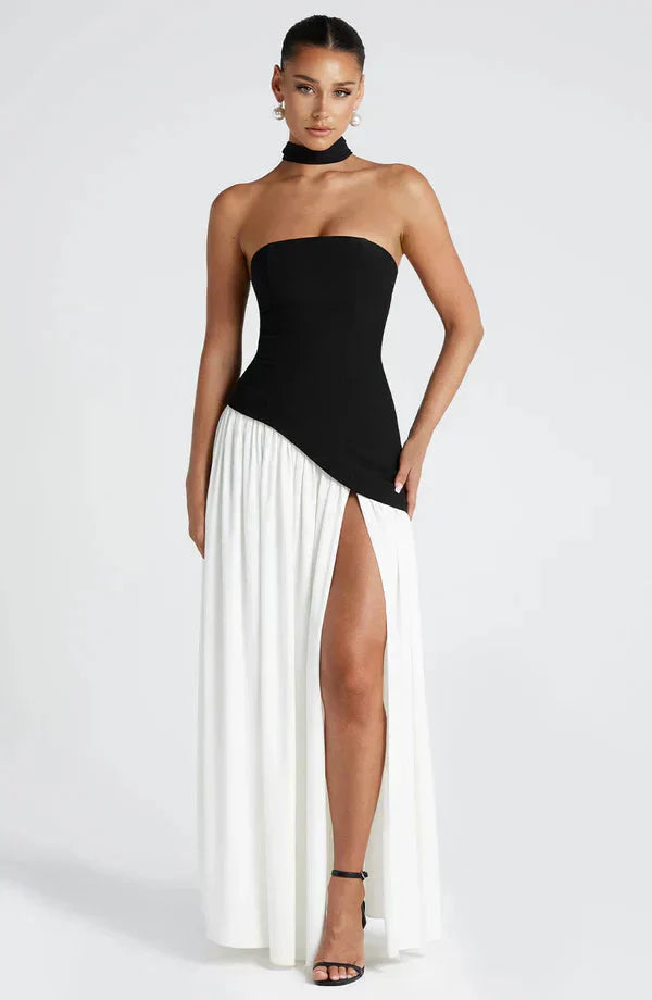 Two-tone maxi dress with a black strapless bodice, white flowing skirt with a high slit, and a black choker.