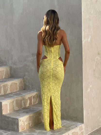 Back view of the yellow Sadie Lace Maxi Dress, highlighting the open back design, corset lacing, and a subtle slit in the skirt.