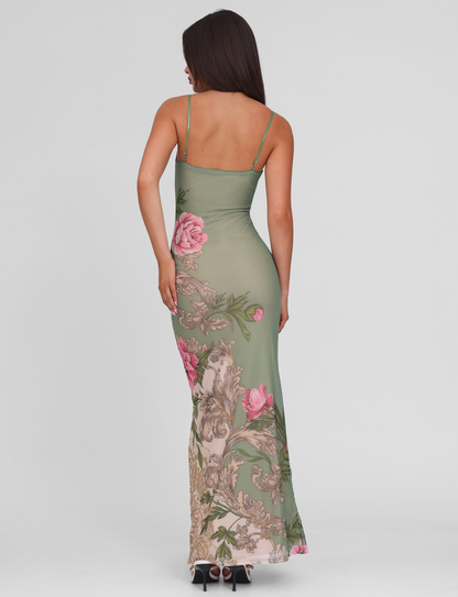 Back view of a woman in the green floral mesh maxi dress, revealing the spaghetti straps and elegant drape.