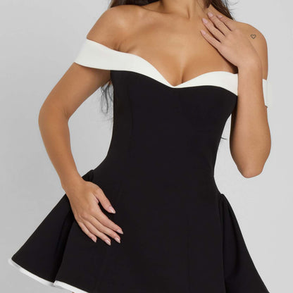 Black off-shoulder mini dress styled with minimal accessories, angled side view.