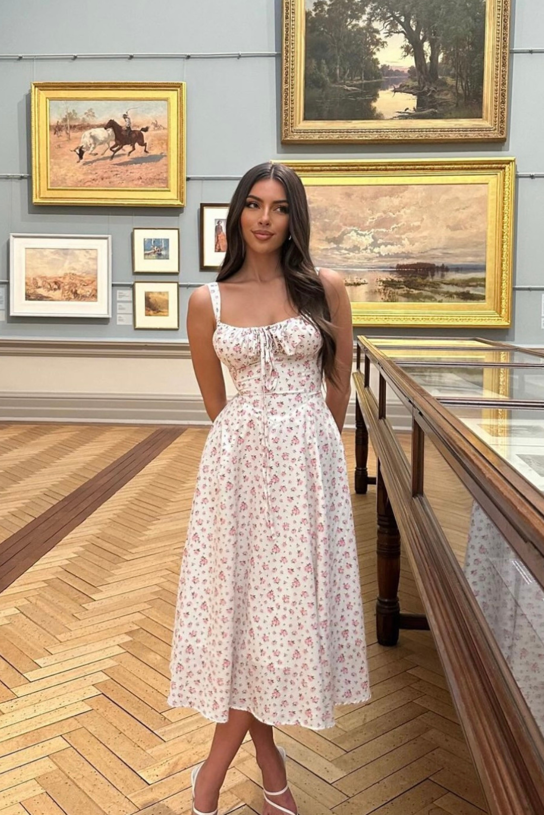 Back view of floral midi dress showcasing adjustable straps and flowing design.